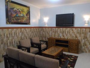 a waiting room with chairs and a flat screen tv at Hotel Sorga Cottages in Kuta