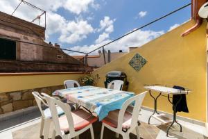 a patio with a table and chairs on a balcony at la casa di Daisy in Carloforte