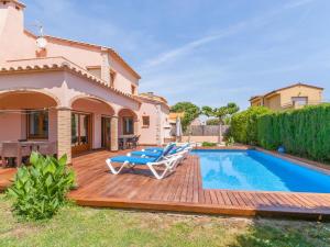 um quintal com um deque de madeira e uma piscina em Belvilla by OYO Amfora 64 em Sant Pere Pescador