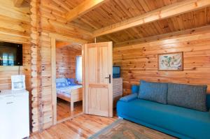 a room with a blue couch in a log cabin at Leśny Dworek in Darłowo