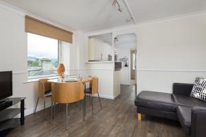 a living room and kitchen with a table and a couch at Balmoral Apartment in Keswick