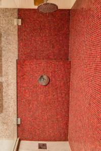 a red tiled shower with a red wall at Chesa Seja - Zuoz in Zuoz