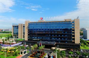 a large building in a city with a parking lot at Airport Jianguo Hotel in Chengdu