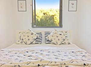 a bed with pillows and a window in a bedroom at Apartments Pirka in Pirovac