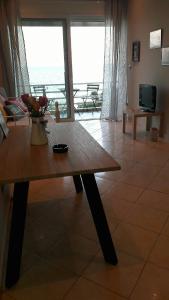 - un salon avec une table et une vue sur l'océan dans l'établissement Goldie's Home by the sea, à Artemi