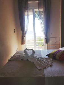 two swans are forming a heart on a bed at Goldie's Home by the sea in Artemida