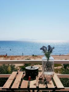 un vase de fleurs assis sur une table de pique-nique près de la plage dans l'établissement Goldie's Home by the sea, à Artemi