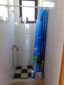 a bathroom with a shower with a blue shower curtain at Guest House Tatyana in Sutomore