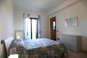 a bedroom with a bed and a dresser and window at Introdacqua Holidays in Introdacqua