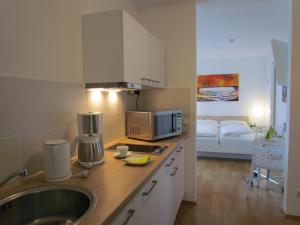 a kitchen with a sink and a microwave at AMENITY-Garden-Apartments in Munich