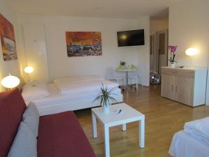 a living room with a bed and a couch and a table at AMENITY-Garden-Apartments in Munich