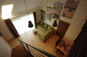 uma vista superior de uma sala de estar com um sofá verde em Almásy Apartmanház Gyula em Gyula