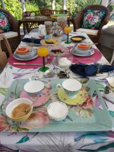 a table with plates and cups and dishes on it at Folly Studio Bed and Breakfast in Bungay
