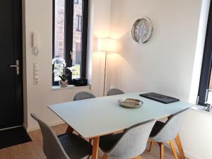 a dining room table with chairs and a clock on the wall at Ostsee Perle 35 in Heiligenhafen