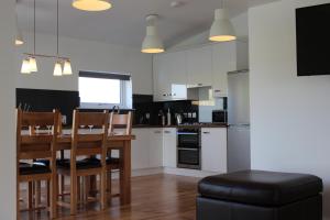 a kitchen with a wooden table and chairs and a dining room at 35 Newvalley in Stornoway