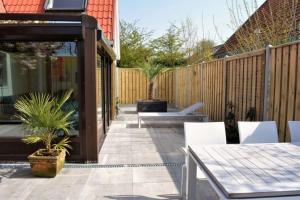 東卡佩勒的住宿－Vroonweg 34 sauna sunshower，一个带桌椅和围栏的庭院