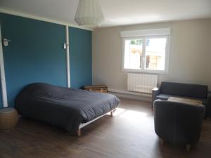 a bedroom with a bed and a couch and a window at Labassere in Labassère