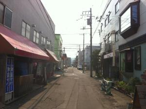 an empty street in an asian city with buildings at Guest House Yasube in Sapporo