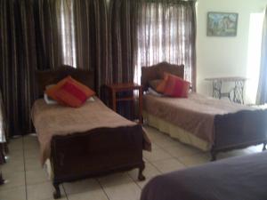 Port Elizabeth Apartment في بورت اليزابيث: غرفة فندقية بسريرين وطاولة