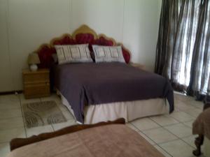 una camera con un grande letto con testiera in legno di Port Elizabeth Apartment a Port Elizabeth