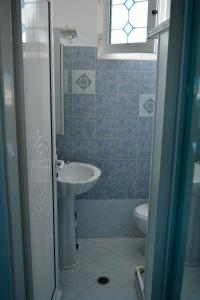 een badkamer met een wastafel, een toilet en een raam bij Stella Beach House in Archangelos
