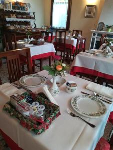 a table in a restaurant with white plates on it at Albergo La Meridiana in Portogruaro