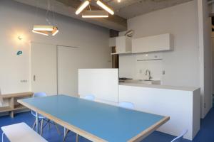 a room with a table and chairs and a kitchen at Wharf Inn in Yokohama