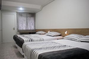 Postel nebo postele na pokoji v ubytování Hotel Dois Irmãos