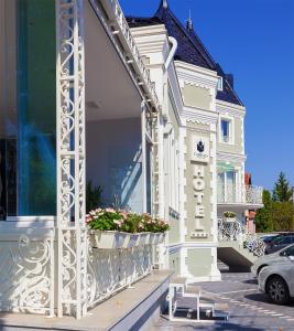 a large white building with a clock on the front of it at Castello Boutique Hotel in Čačak