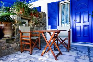 a wooden table and chairs next to a blue door at Dina Naxos Studios in Agios Prokopios