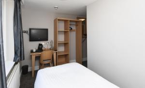 a bedroom with a bed and a desk with a television at Crown, Droitwich by Marston's Inns in Droitwich