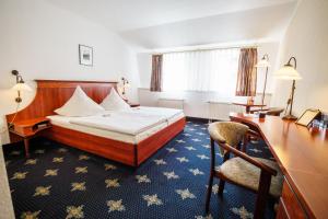 a hotel room with a bed and a desk at Hotel Wilder Mann Annaberg-Buchholz in Annaberg-Buchholz