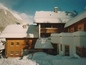 a building covered in snow with snow covered roofs at Hotel Garni Alpenblick in Ischgl