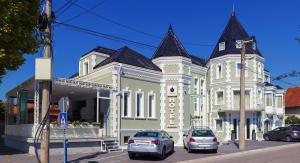 a building with cars parked in front of it at Castello Boutique Hotel in Čačak