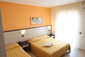 une chambre d'hôtel avec deux lits et une fenêtre dans l'établissement Hotel Cristall, à San Benedetto del Tronto 26 autres photos