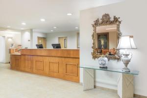 a reception desk in a hospital lobby with a mirror at Super 8 by Wyndham Hagerstown/Halfway Area in Hagerstown