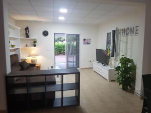a living room with a couch and a tv at Chalet Bacarot in Alicante