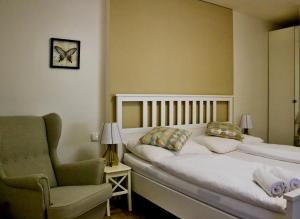 1 dormitorio con 1 cama, 1 silla y 1 reloj en Hotel Drnholec en Drnholec