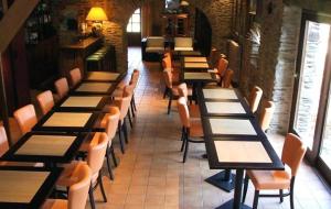a dining room filled with tables and chairs at Le Relais des Arcandiers in Lohéac