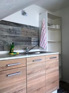 a kitchen with wooden cabinets and a sink at PENNY Ferienwohnung in Velpke