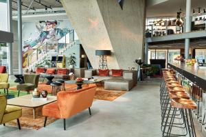 a lobby with couches and chairs and a bar at Sir Adam Hotel, part of Sircle Collection in Amsterdam