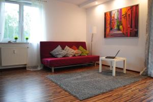 a living room filled with furniture and a painting on the wall at MT Apartments in Nowy Tomyśl