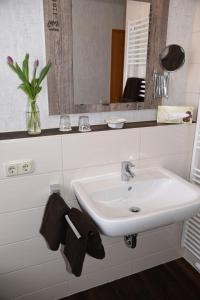 a bathroom with a white sink and a mirror at Hartlef´s Gasthof in Stade