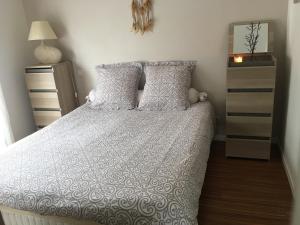 um quarto com uma cama com lençóis brancos e almofadas em Nano House em Bègles