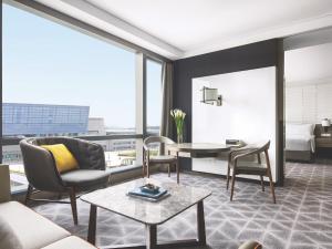 a living room filled with furniture and a window at Cordis Shanghai Hongqiao (Langham Hospitality Group) in Shanghai