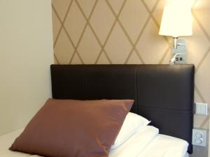 a bed with a white comforter and pillows at Thon PartnerHotel Skagen in Bodø