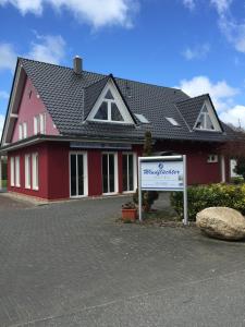 a red house with a sign in front of it at Hotel Windflüchter in Breege
