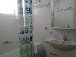 a bathroom with a sink and a shower curtain at Garden of Edem in Afissos