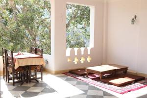 a dining room with a table and chairs and a window at Haveli Katkoun in Būndi