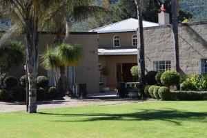 a house with palm trees in front of it at Gate 66 in Somerset East
